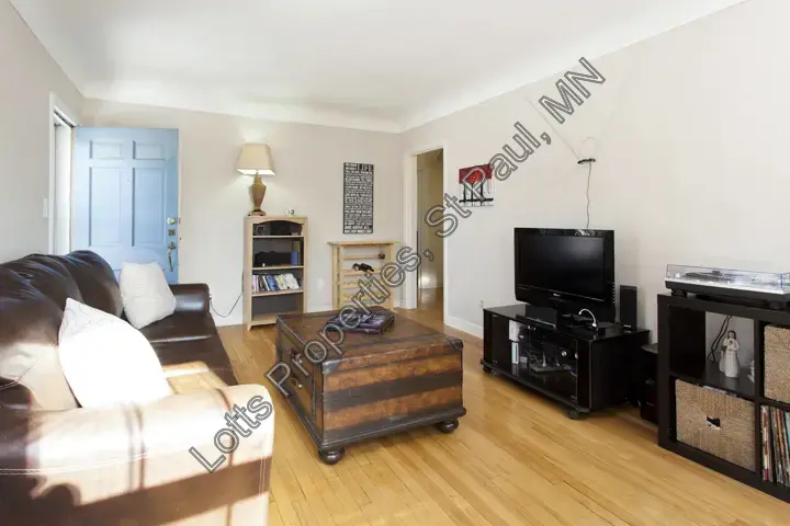 Living room at 1444 Alameda with media console and front entry