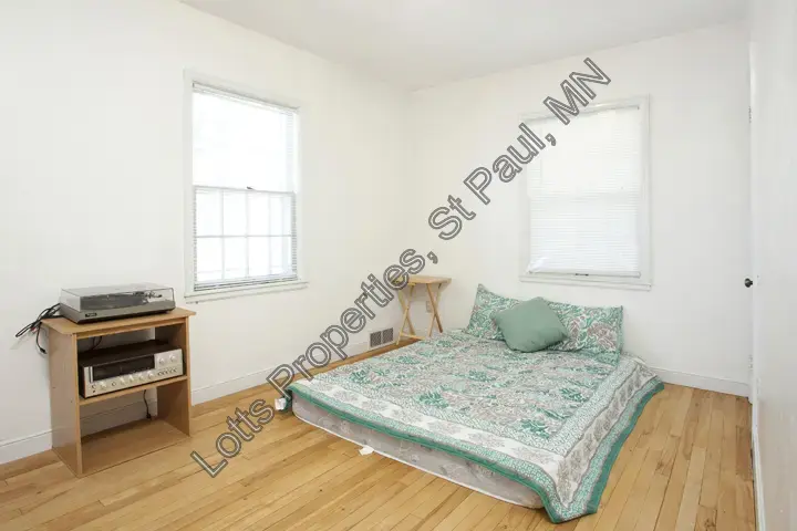 Main-floor west bedroom with hardwood floors and natural light