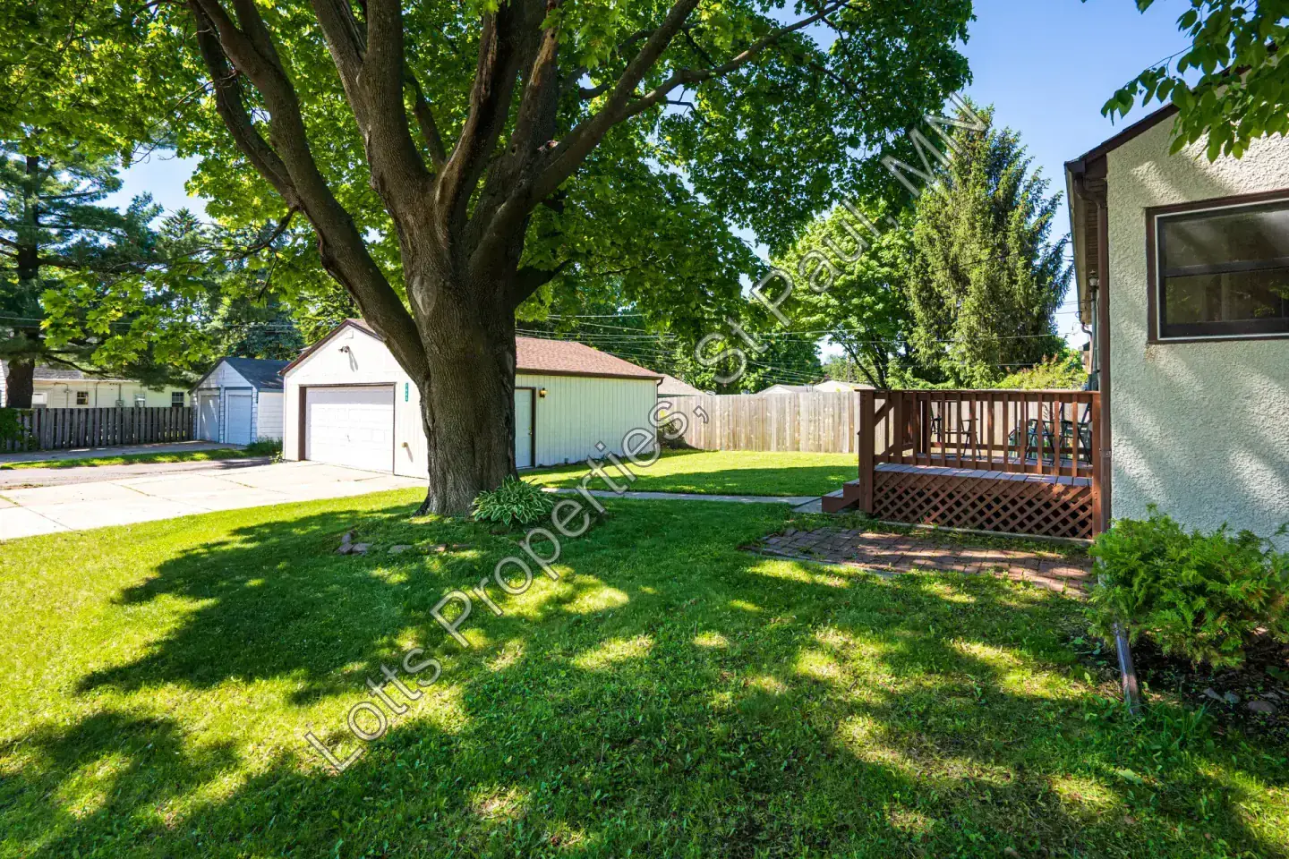 Backyard lawn with detached garage and privacy fence