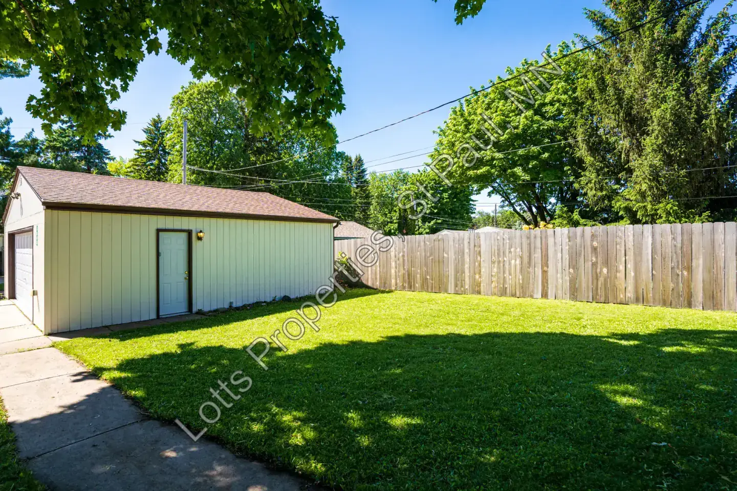Rear yard view looking toward the garage and neighboring fence