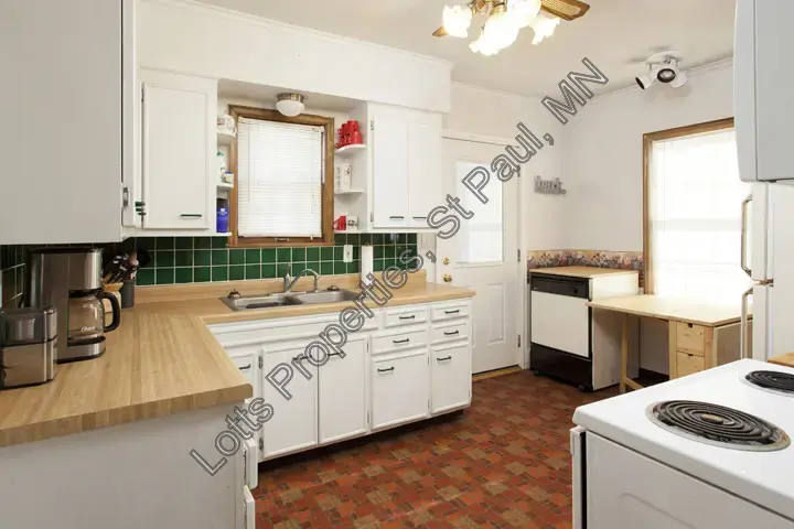 Pre-remodel kitchen view with cabinetry, counters, and laundry area