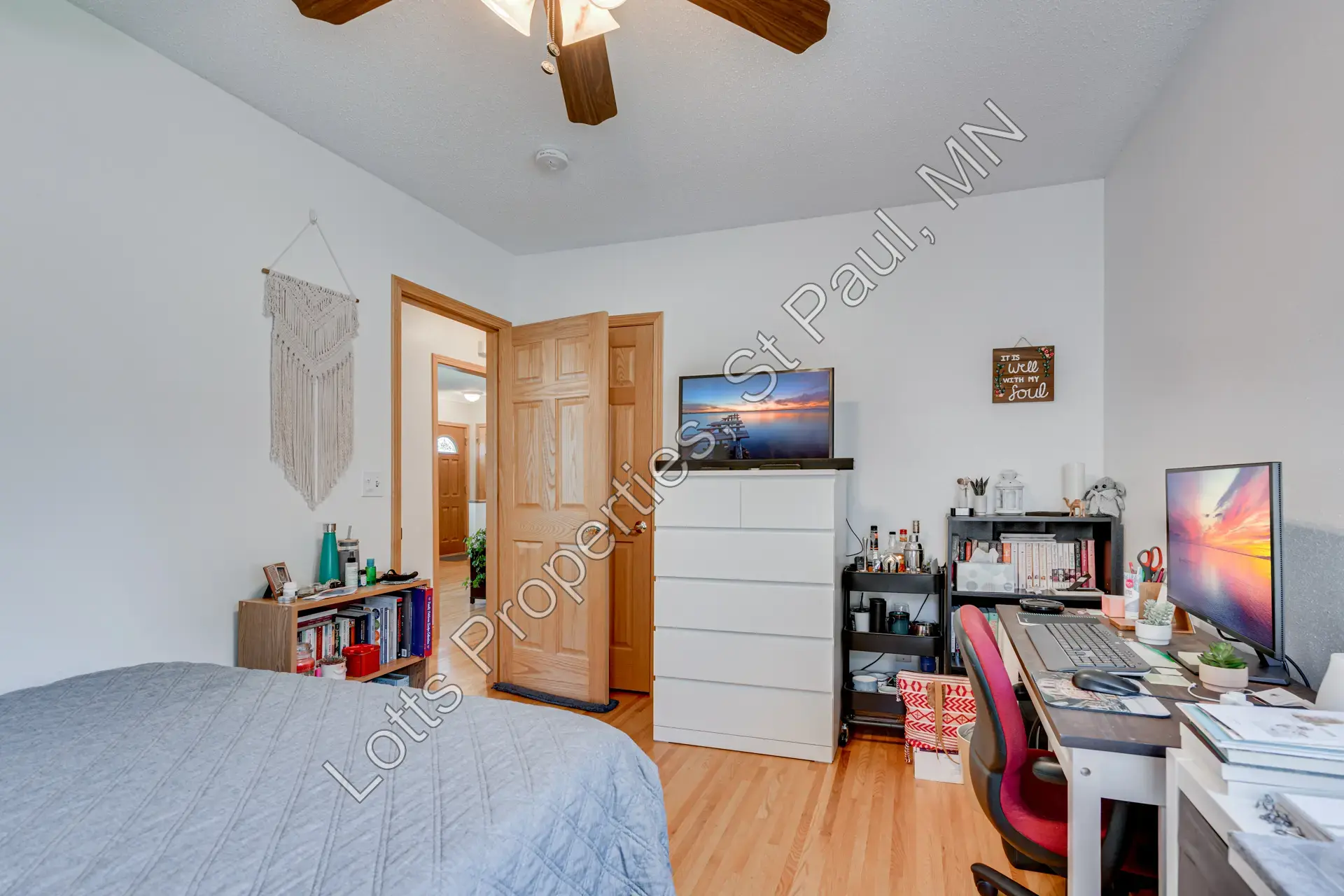 East main-floor bedroom near the front of the house with large windows and hardwood floors