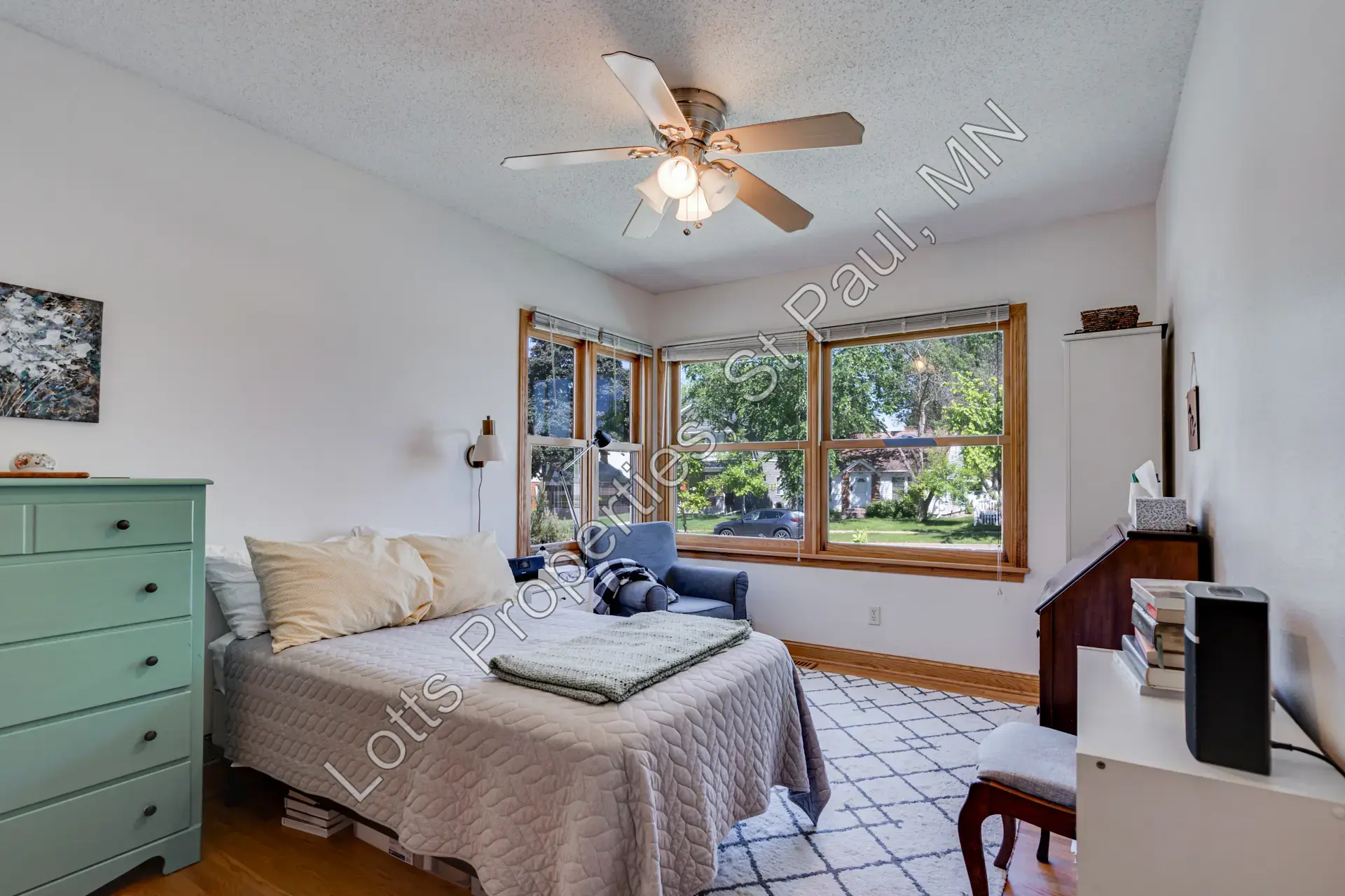 East main-floor bedroom with large front-facing windows and natural light