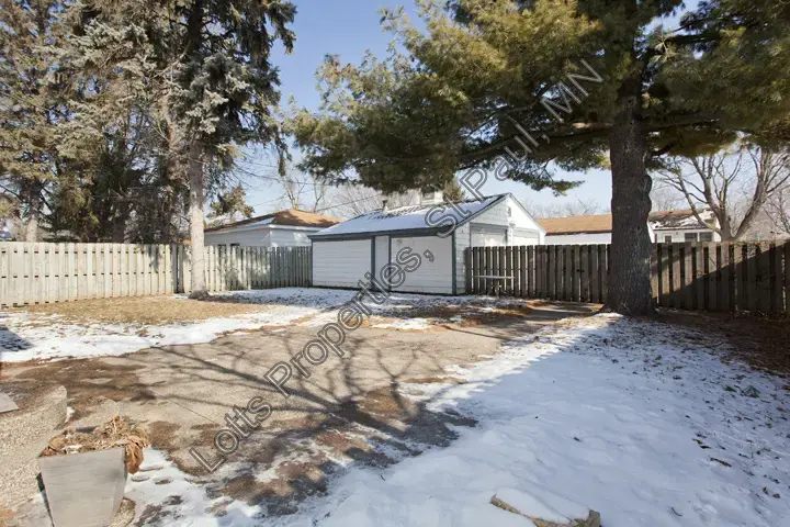 Backyard view with open space and detached garage before recent exterior updates