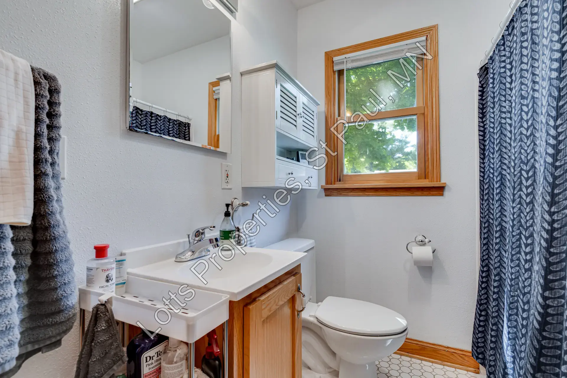 Bathroom with vanity, tub-shower combo, and window for natural light