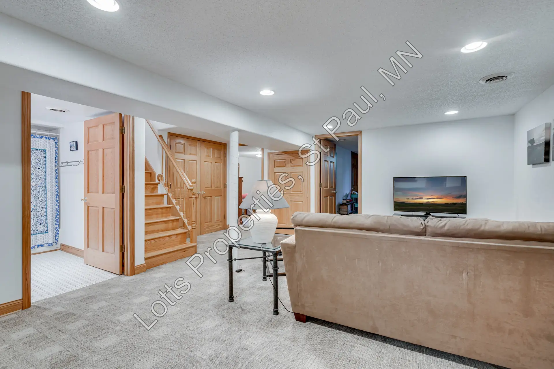 Finished basement family room with wet bar and recessed lighting