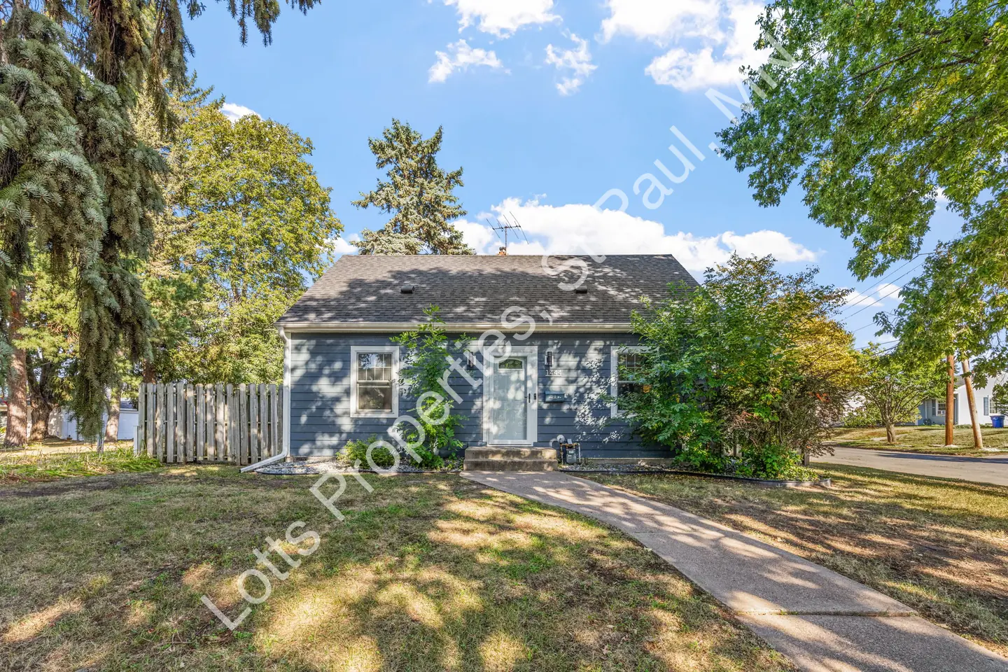 Front exterior of 1444 Alameda, a blue two-story cottage with white trim and a walkway across the front lawn.