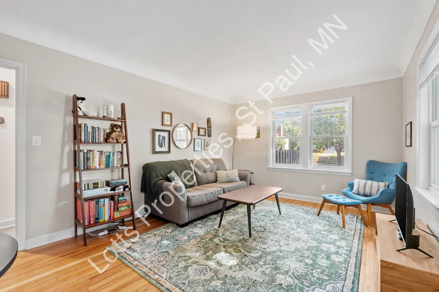 Living room at 1444 Alameda with hardwood floors, a sofa, and a sunny double window.