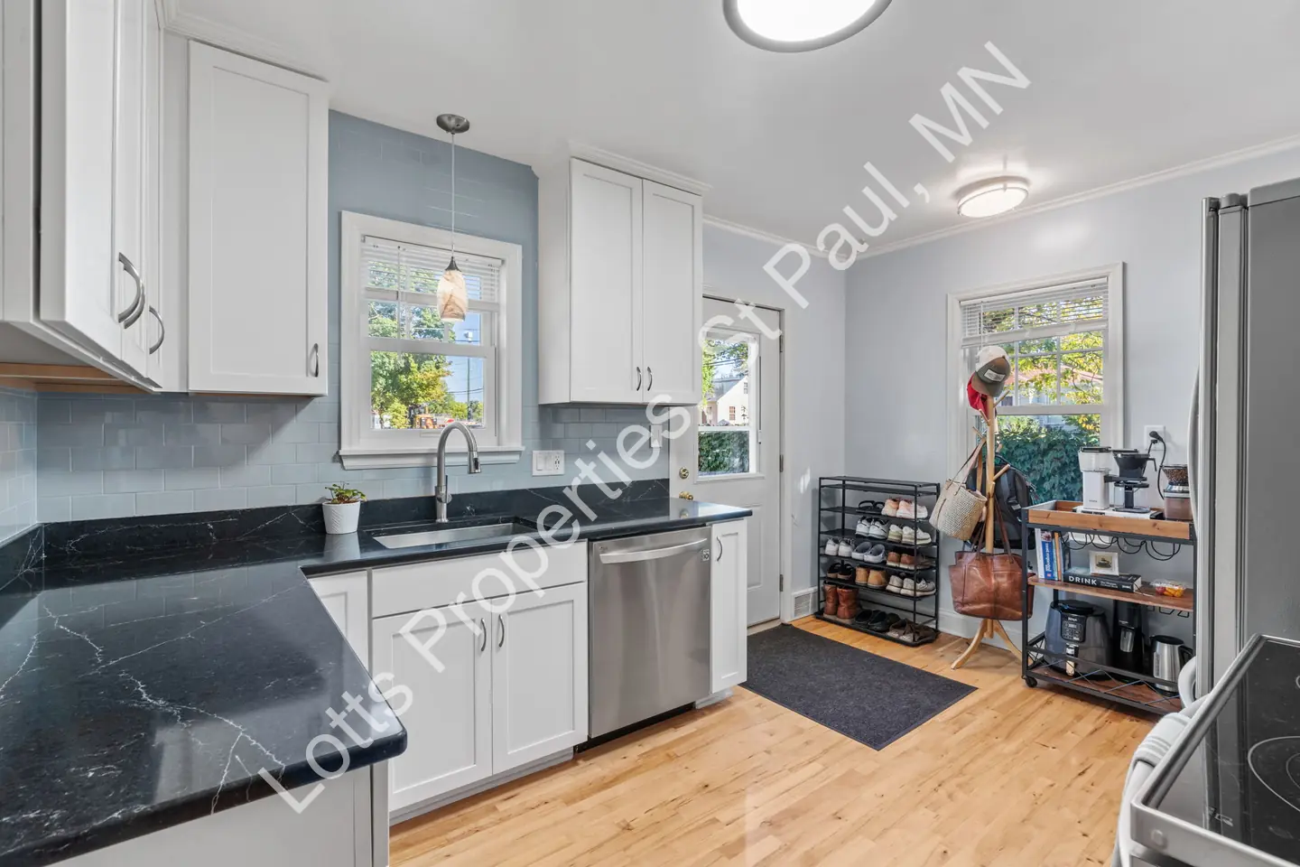 Kitchen at 1444 Alameda with white cabinets, dark counters, and stainless steel appliances.