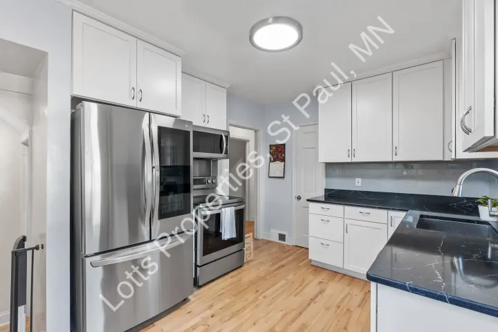 Remodeled kitchen at 1444 Alameda with white cabinets, dark counters, and stainless steel appliances