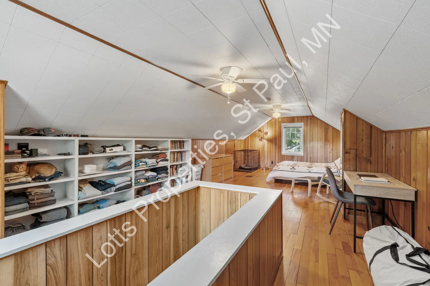 Upstairs storage nook with built-in cubby shelving, a desk, and a distant window.