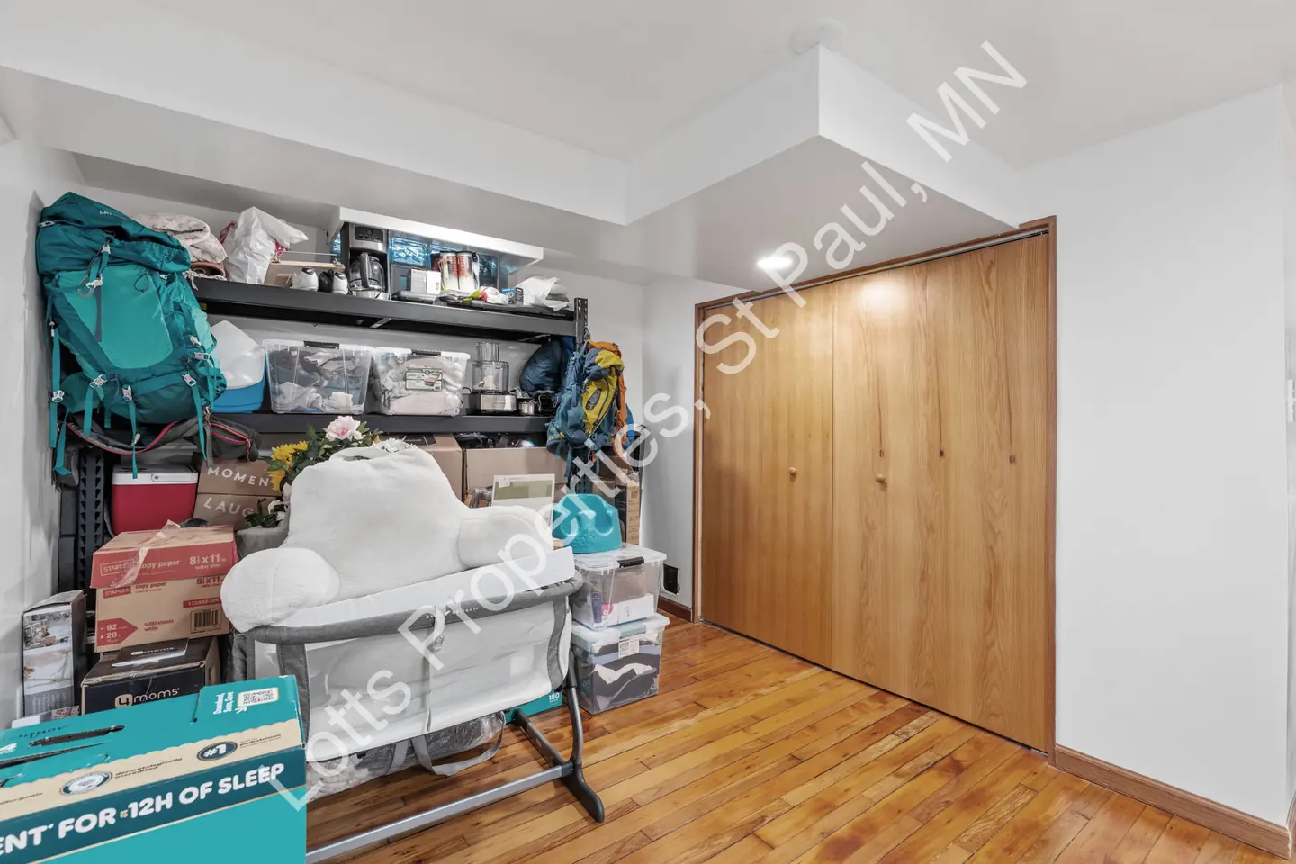 Basement storage room with shelving and a large sliding wood closet door.