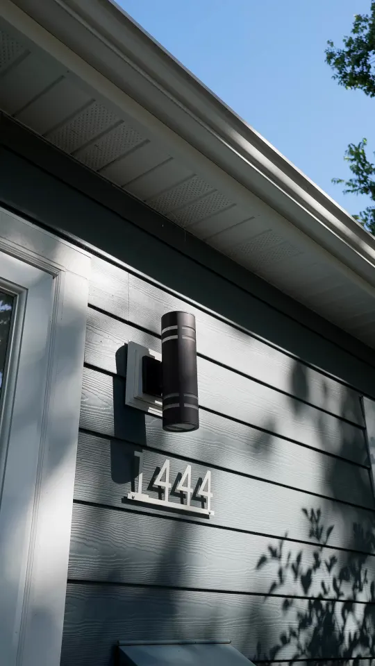 Front corner of 1444 Alameda with new gray siding, a black exterior light, and the house number 1444.